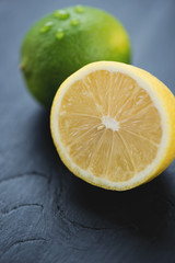 Naklejka na ściany i meble Sliced lemon and whole lime, close-up, vertical shot