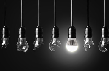 Idea concept with broken bulbs and one glowing LED bulb