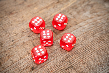 Six numbers on faces of five red dices on wooden floor