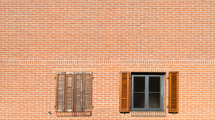 facade of a building with two windows, brick wall