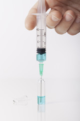 Syringe taking a blue liquid in laboratory