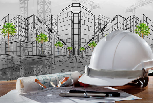 safety helmet and architect pland on wood table with sunset scen
