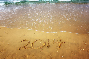 New Year 2014 is coming concept written on beach sand