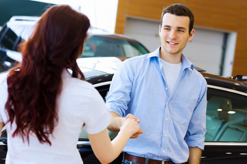 Young happy couple at car salon