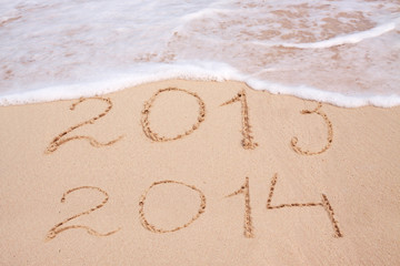  Year 2014 written in sand on tropical beach .