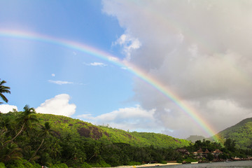 Rainbow over tropical island and white beach at Seychelles