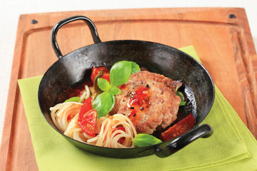 Meat patty with tomatoes and spaghetti