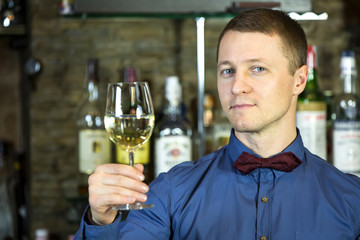 young man working as a bartender in a nightclub bar