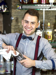 young man working as a bartender in a nightclub bar