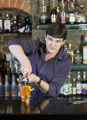 young man working as a bartender in a nightclub bar