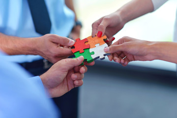Group of business people assembling jigsaw puzzle