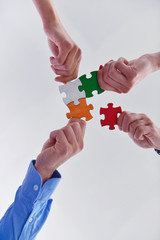 Fototapeta premium Group of business people assembling jigsaw puzzle
