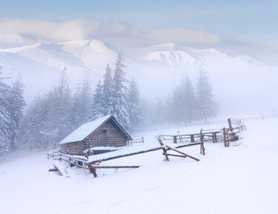 Fototapeta na wymiar Leśniczówka chaty pokryte śniegiem w górach