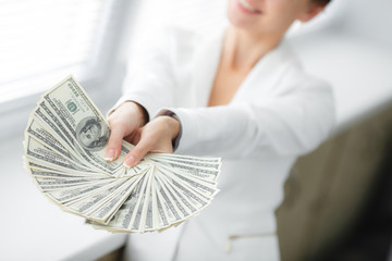 A young woman with dollars in her hands, isolated on white