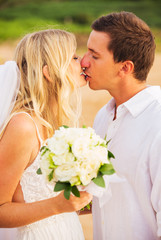 Bride and Groom, Kissing at Sunset on a Beautiful Tropical Beach