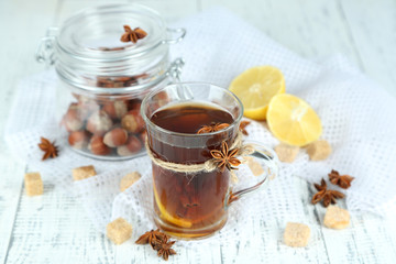 Hot beverage in glass cup with fruits and spices,