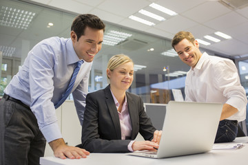 A business team of three in office and planning work