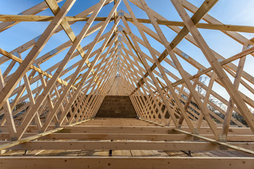 Wood house truss against blue sky  - 59382010