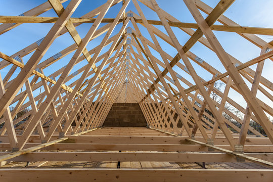 Wood house truss against blue sky 