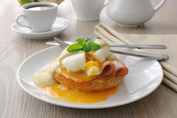 eggs (poached) with ham on a bun with sauce