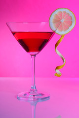 Red cocktail in martini glass  on pink background