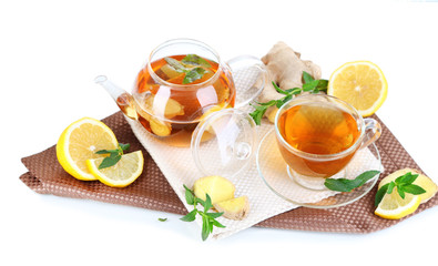 Kettle and cup of tea with ginger on napkin isolated on white