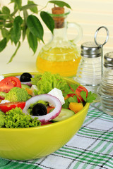 Greek salad on plate on table on light background