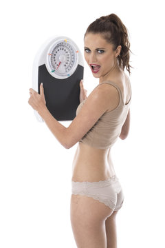 Shocked Young Woman Holding Bathroom Scales
