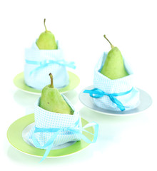 Pears in napkins on plates isolated on white