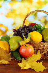 Different fruits and vegetables with yellow leaves in basket