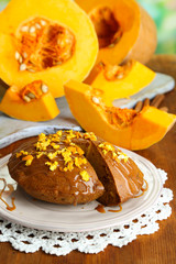 Delicious pumpkin pie on plate on wooden table close-up