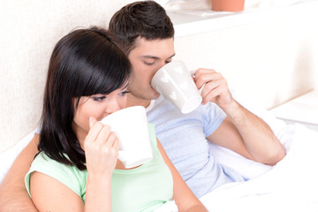 Couple in love drinking coffee in bed