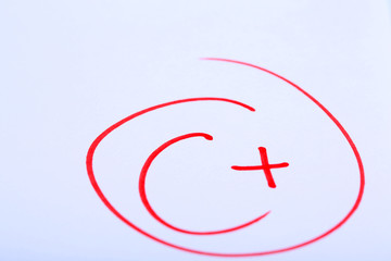 Grade C+ written on an exam paper