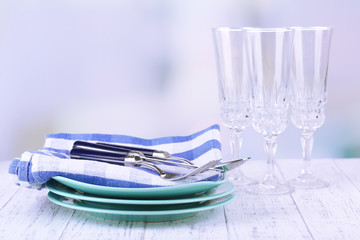 Clean dishes on wooden table on light background