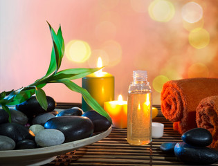 preparation for massage in orange with dish, oil and bamboo