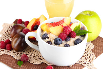 Oatmeal in cup with berries on napkins isolated on white