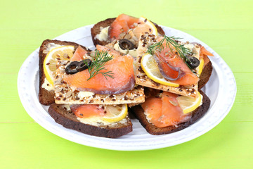 Salmon sandwiches on plate  on wooden table close-up