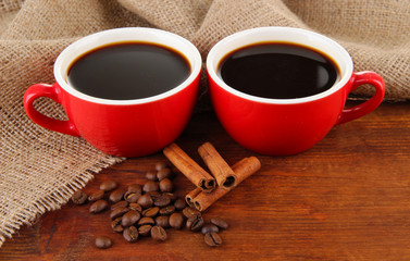 Red cups of strong coffee and coffee beans