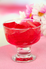 Tasty jelly cubes in bowl on table on light background