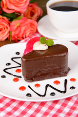 Sweet cake with chocolate on plate on table close-up