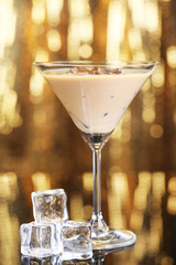 Baileys liqueur in glass on golden background