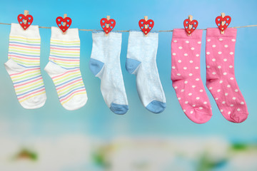 Socks hanging on clothesline on bright background