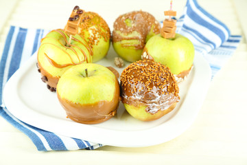 Homemade taffy apples, on napkin, on wooden background