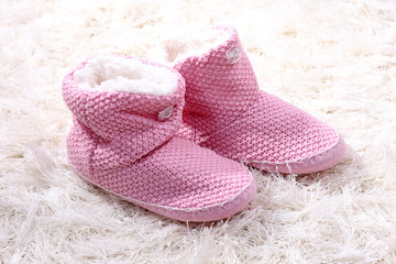 Warm winter home shoes on color background