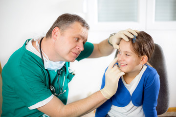 Fototapeta premium Doctor with little girl,doctor putting bandage