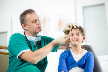 Obraz premium Doctor with little girl,doctor putting bandage