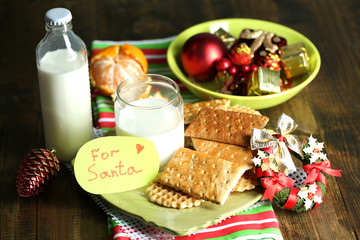 Obraz na płótnie Canvas Cookies and milk for Santa. in wooden background