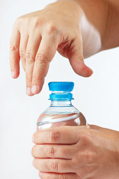 Female hands opening a small bottle of mineral water