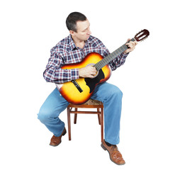 Adult man plays a guitar sitting on an chair