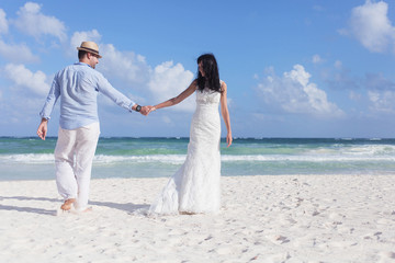 Fototapeta na wymiar Beautiful couple on the beach in wedding dress